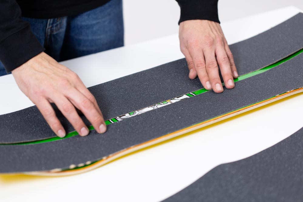 Putting on narrower griptape on wide decks