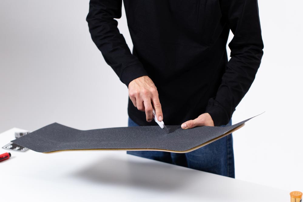 Putting on skateboard griptape