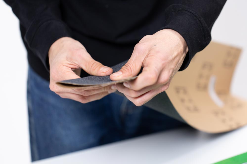 Putting on narrower griptape on wide decks